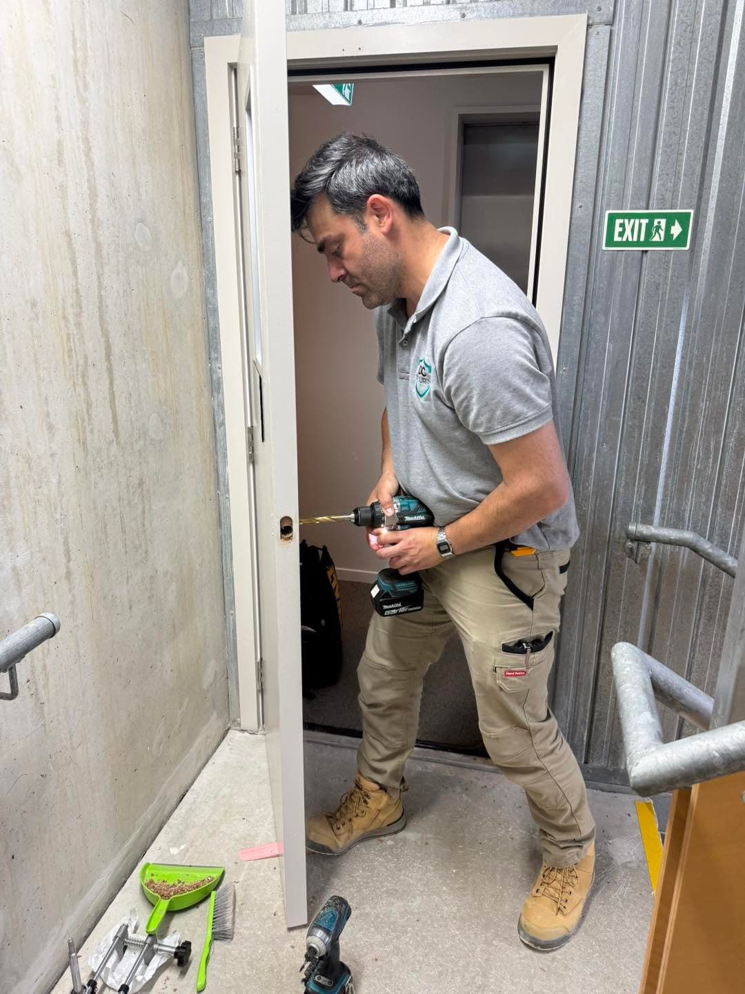 Technician installing door security hardware